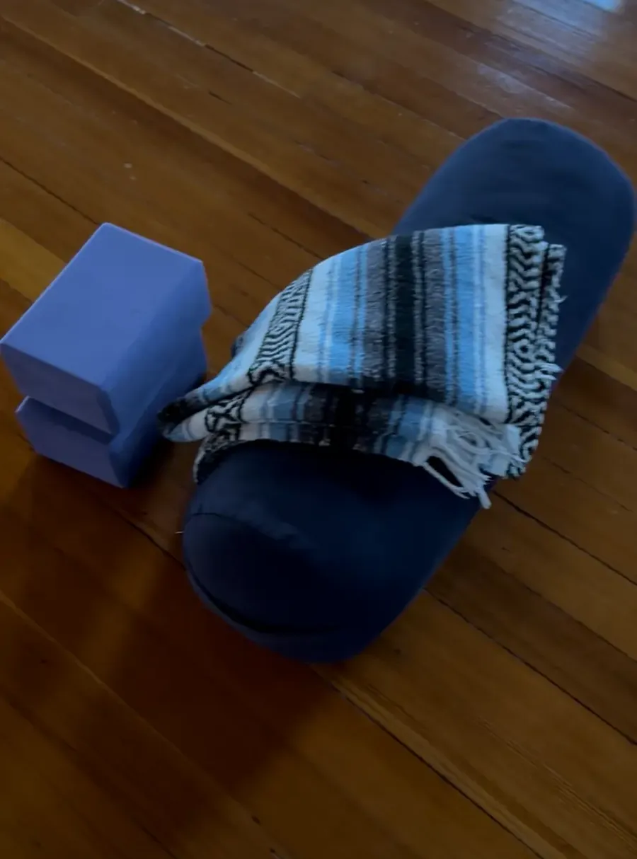 Blue bolster, blocks and a folded blanket on the studio's wood floor